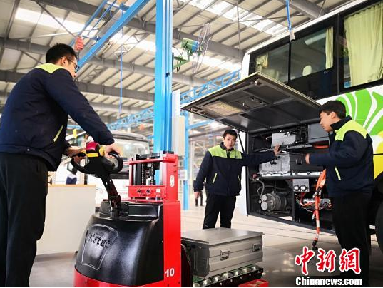 图为工作人员在给新能源车辆安装蓄电池。魏建军 摄